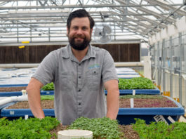 1-kaben-smallwood-stands-behind-a-growbed-full-of-herbs-at-the-eastern-oklahoma-state-college-aquaponic-greenhouse-in-wilburton-oklahoma