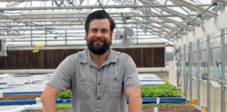 1-kaben-smallwood-stands-behind-a-growbed-full-of-herbs-at-the-eastern-oklahoma-state-college-aquaponic-greenhouse-in-wilburton-oklahoma